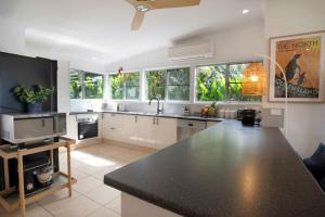a kitchen with a black counter top and some windows at Tide Pool Ocean Front 2 bed in South Mission Beach