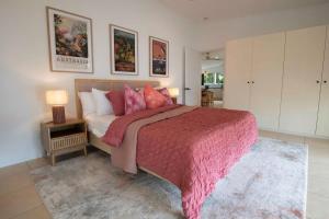 a bedroom with a large bed with a pink blanket at Tide Pool Ocean Front Full house in South Mission Beach +42 photos