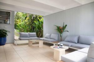 a living room with couches and tables and plants at Tide Pool Ocean Front 2 bed in South Mission Beach