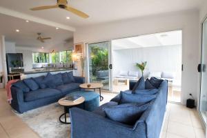 a living room with blue couches and a kitchen at Tide Pool Ocean Front Full house in South Mission Beach