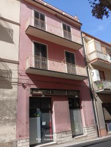 a pink building with balconies on the side of it at Vico Girone in Patti