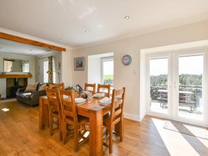 a dining room and living room with a table and chairs at Heron View in Kirkcudbright