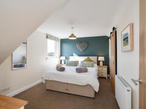 a bedroom with a bed and a blue wall at Heron View in Kirkcudbright