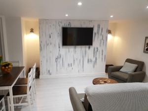 a living room with a television on a wall at Cottage Apartment - Uk2774 in Llandudno