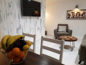 a living room with a bowl of fruit on a table at Cottage Apartment - Uk2774 in Llandudno +18 photos