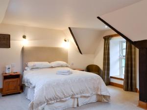 a bedroom with a bed with white sheets and a window at The Stable - 31240 in Kilmartin