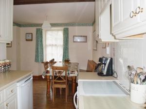 a kitchen with a table and a dining room at The Stable - 31240 in Kilmartin