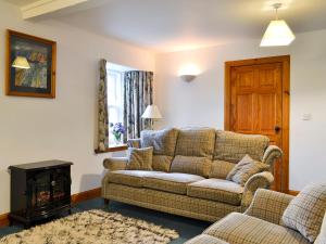 a living room with a couch and a fire place at The Stable - 31240 in Kilmartin
