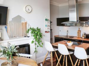 a kitchen with a wooden table and white chairs at Seaside Apartment-Uk2801 in Aberystwyth