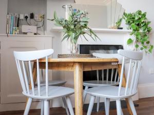 a kitchen with a wooden table and two white chairs at Seaside Apartment-Uk2801 in Aberystwyth
