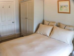 a bed with white sheets and pillows in a room at Seaside Apartment-Uk2801 in Aberystwyth +6 photos