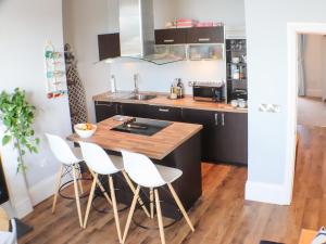 a kitchen with a wooden table and white chairs at Seaside Apartment-Uk2801 in Aberystwyth