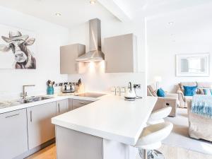 a white kitchen with a cow picture on the wall at The Kings in York