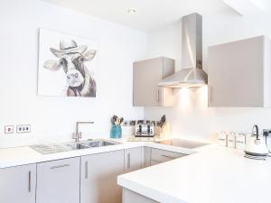 a kitchen with a cow with a cowboy hat on the wall at The Kings in York