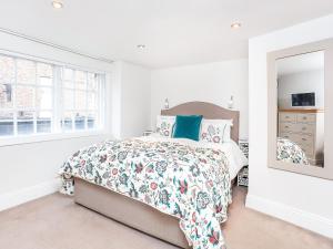a white bedroom with a bed and a mirror at The Kings in York +9 photos