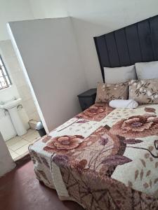 a bedroom with a bed with a quilt on it at Empangeni guest house 2 in Empangeni
