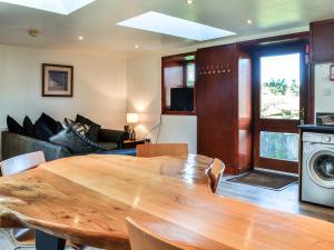 a living room with a wooden table and a couch at Ochiltree Cottage - Uk7781 in Newton Stewart