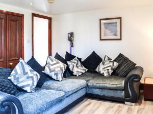 a living room with a couch with pillows on it at Ochiltree Cottage - Uk7781 in Newton Stewart