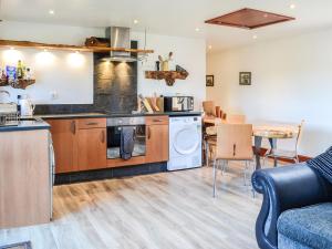 a kitchen and dining room with a couch and a table at Ochiltree Cottage - Uk7781 in Newton Stewart