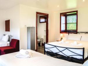 a hotel room with two beds and a red chair at Ochiltree Cottage - Uk7781 in Newton Stewart +6 photos
