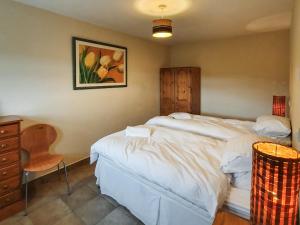a bedroom with a large bed and a chair at The Stables - Uk7791 in Milton of Auchinhove