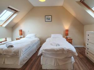 two beds in a attic bedroom with two windows at The Stables - Uk7791 in Milton of Auchinhove +3 photos