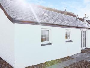 a white house with two windows and a roof at Dondies House in Kilchoan