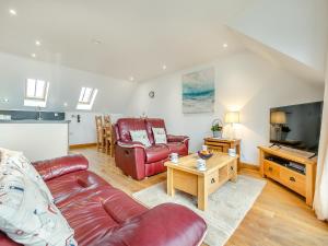 a living room with a couch and a television at 23 Mount Brioni in Downderry