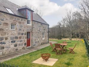 a stone house with a table and chairs in the yard at Greenlands in Banchory +2 photos