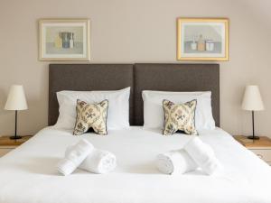 a bedroom with a white bed with four pillows at Greenlands in Banchory