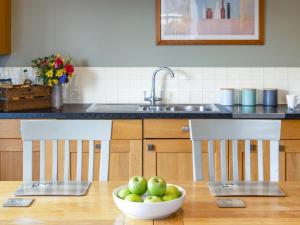 a kitchen with two chairs and a bowl of apples on a table at Greenlands in Banchory