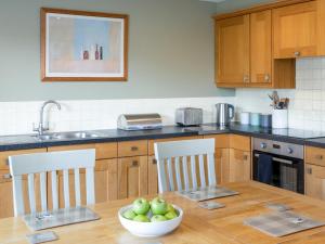a kitchen with a table with a bowl of apples on it at Greenlands in Banchory