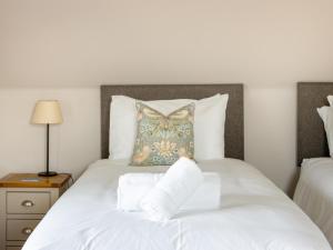 a bed with white sheets and a pillow on it at Greenlands in Banchory