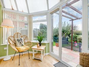 a room with a conservatory with windows and a chair at Anchors Away - 29566 in Blue Anchor