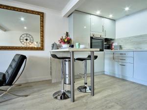 a kitchen with a table and chairs in a room at Imperial Apartment in Oban