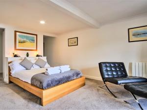 a bedroom with a bed and a black chair at Imperial Apartment in Oban +11 photos