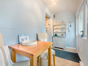 a dining room with a wooden table and a kitchen at Anchors Away - 29566 in Blue Anchor +12 photos