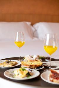 a tray with plates of food and two glasses of wine at Hotel IBY in New Delhi