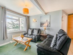 a living room with a couch and a table at 6 Mount Brioni in Downderry