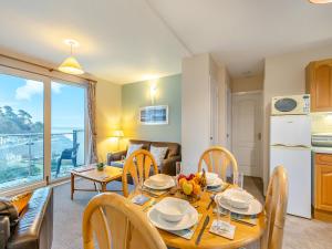 a kitchen and living room with a table and chairs at 12 Mount Brioni in Downderry