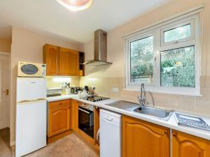 a kitchen with a white refrigerator and a sink at 12 Mount Brioni in Downderry