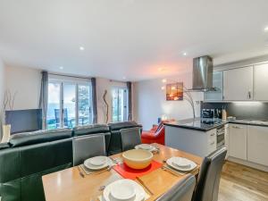 a kitchen and living room with a table and a couch at 21 Mount Brioni in Downderry