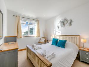 a bedroom with a bed with blue pillows and a desk at 18 Mount Brioni in Downderry +13 photos
