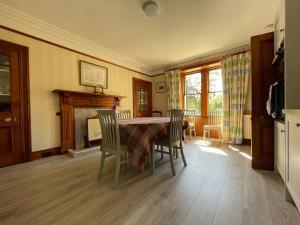 a dining room with a table and chairs and a fireplace at Balloan House-Uk7383 in Dornoch
