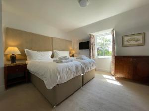 a bedroom with a large bed and a window at Balloan House-Uk7383 in Dornoch +7 photos