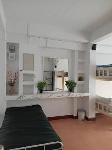 a white room with a mirror and a bed at Middle Road Hostel in Nathon Bay