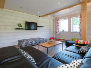 een woonkamer met twee blauwe banken en een tv bij Heritage Holiday Home in Ovifat with Sauna in Waimes