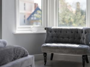 a couch sitting in a room with a window at Coastal Gem - Uk2773 in Llandudno