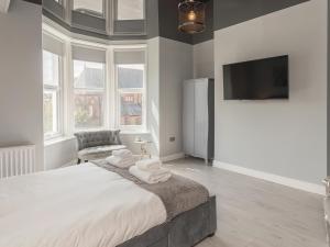 a bedroom with a large bed and a flat screen tv at Coastal Gem - Uk2773 in Llandudno