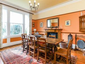 a dining room with a table and chairs and a fireplace at Downedge in Brading